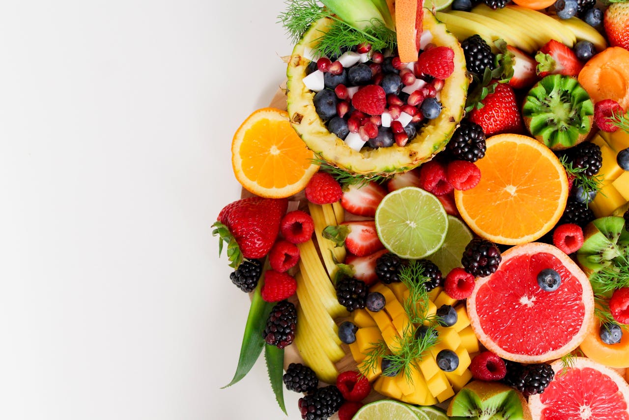 portfolio-02 Colorful flat lay of assorted tropical fruits including pineapple, berries, and citrus.